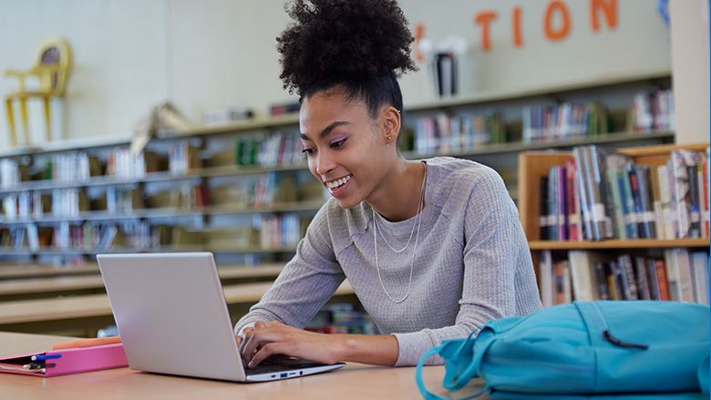 A female student smiles at her computer